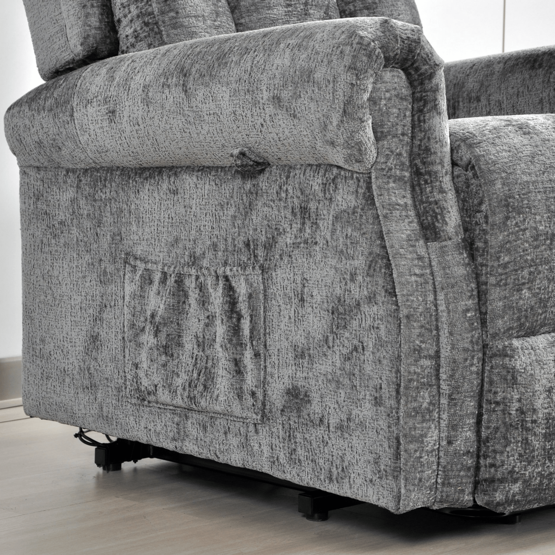 Gray fabric armchair with visible wear and tear on a light wooden floor.