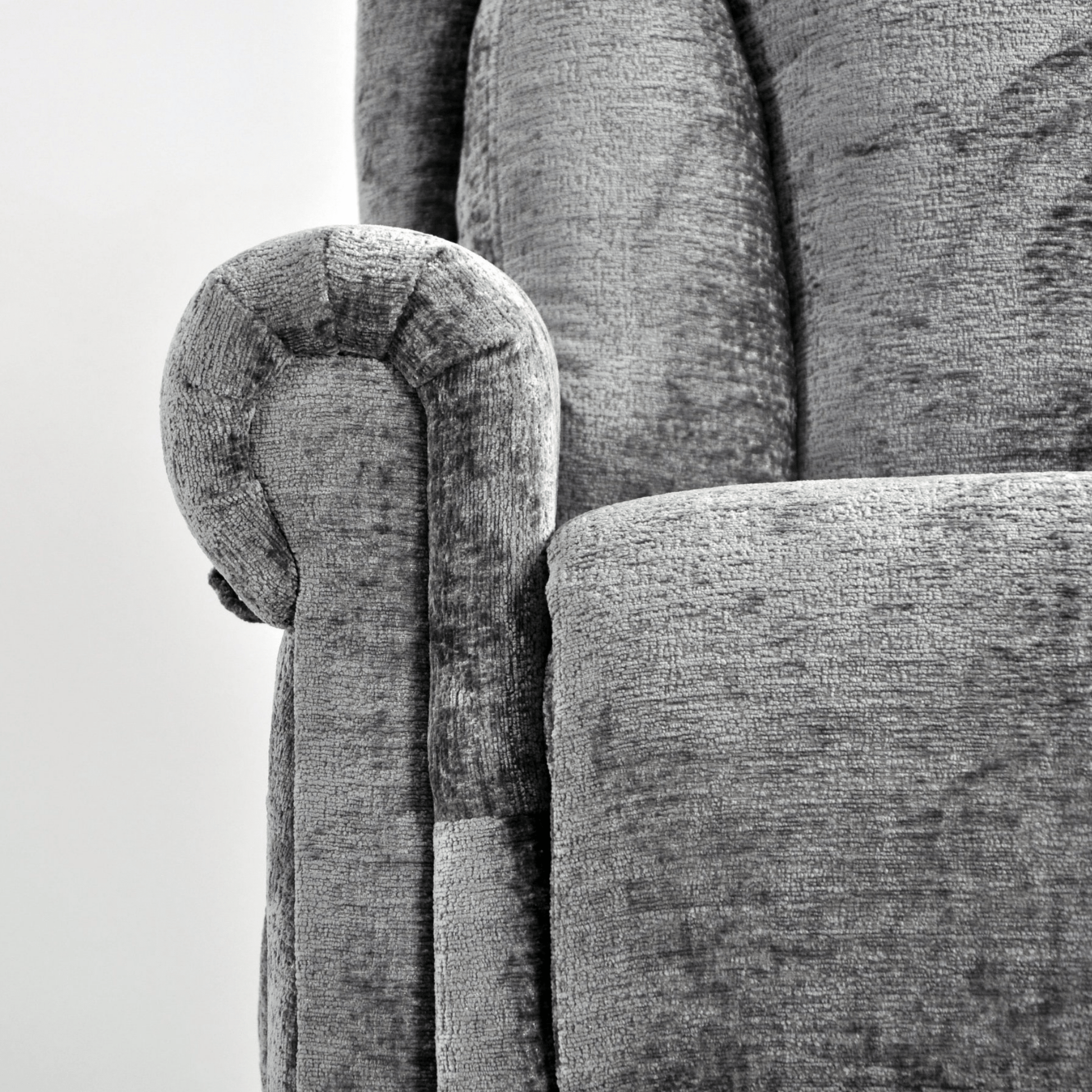 Close-up of a textured gray sofa with wooden armrest detail.