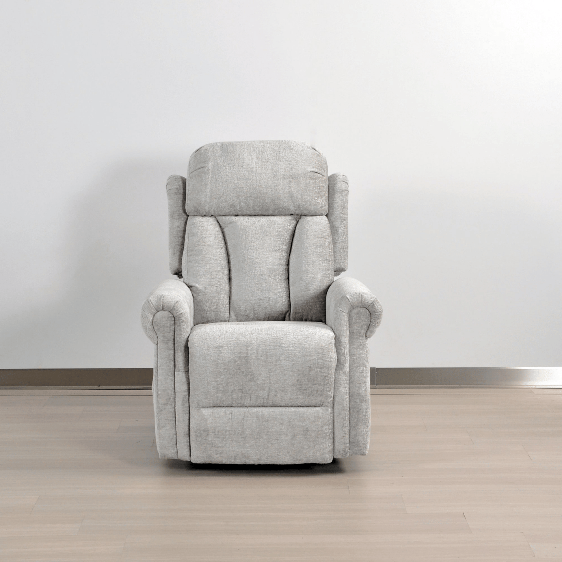 Gray recliner chair on a wooden floor with a white wall background