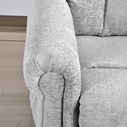 Close-up of a textured gray sofa armrest on a light wooden floor.