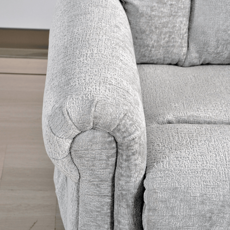 Close-up of a textured gray sofa armrest on a light wooden floor.
