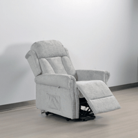 Gray recliner chair on a wooden floor with a white wall background
