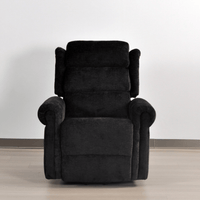 Black recliner chair on a light wooden floor with a white wall background