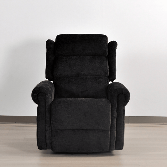 Black recliner chair on a light wooden floor with a white wall background