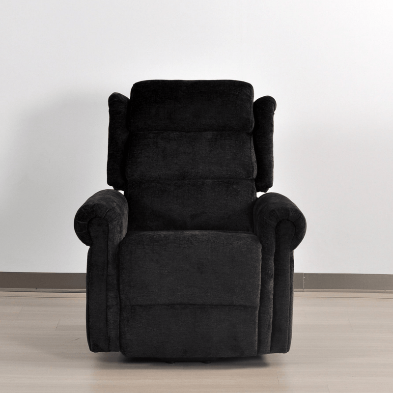 Black recliner chair on a light wooden floor with a white wall background