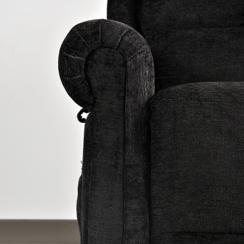 Close-up of a dark gray upholstered chair with armrest detail.