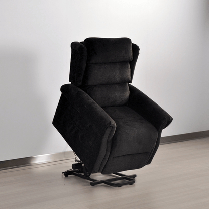 Dark gray recliner chair on a light wooden floor with a white wall background