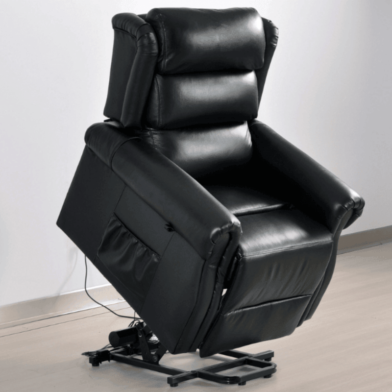 Black leather recliner chair on a light wooden floor with a white wall background