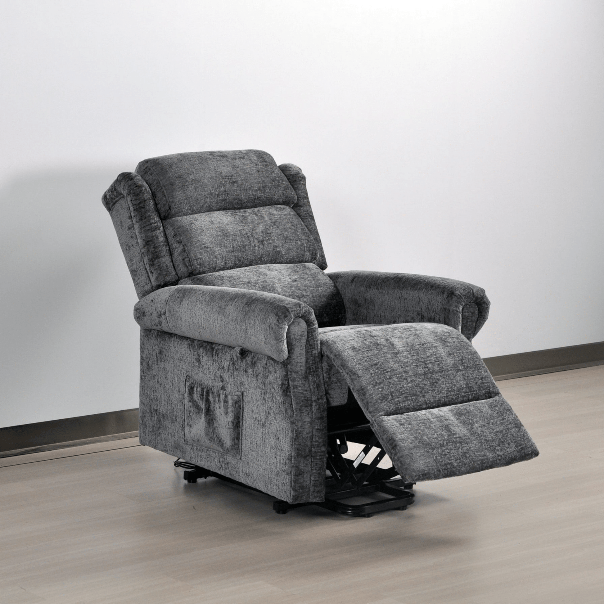 Gray recliner chair on a wooden floor with a white wall background