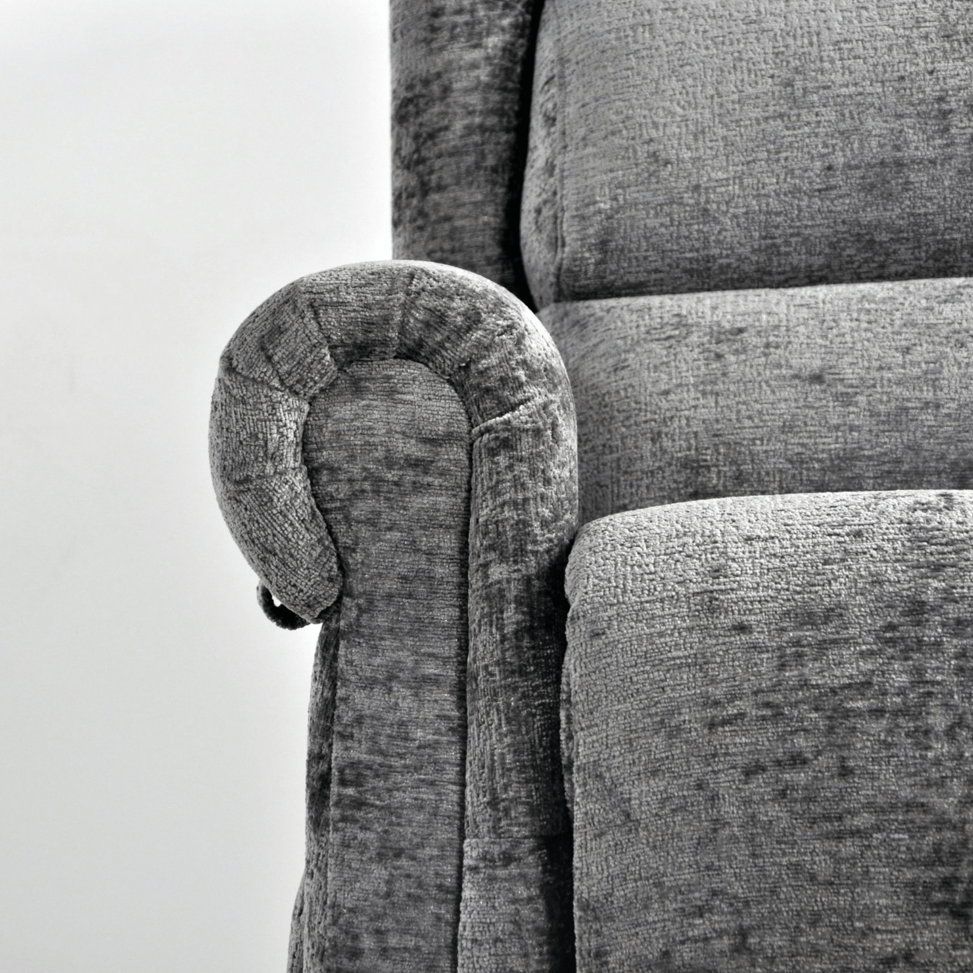 Gray upholstered chair with a curved armrest on a white background