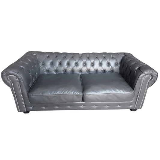 Gray leather sofa with tufted backrest on a white background
