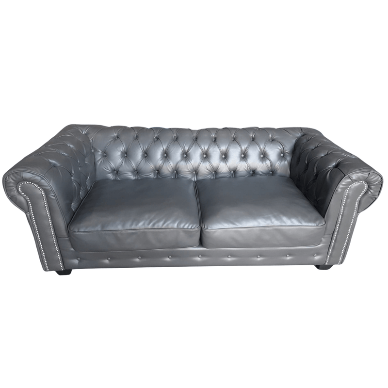 Gray leather sofa with tufted backrest on a white background