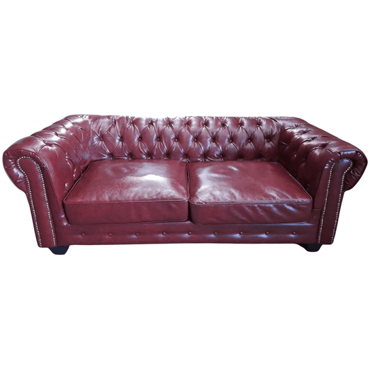 Maroon leather sofa with tufted backrest on a white background