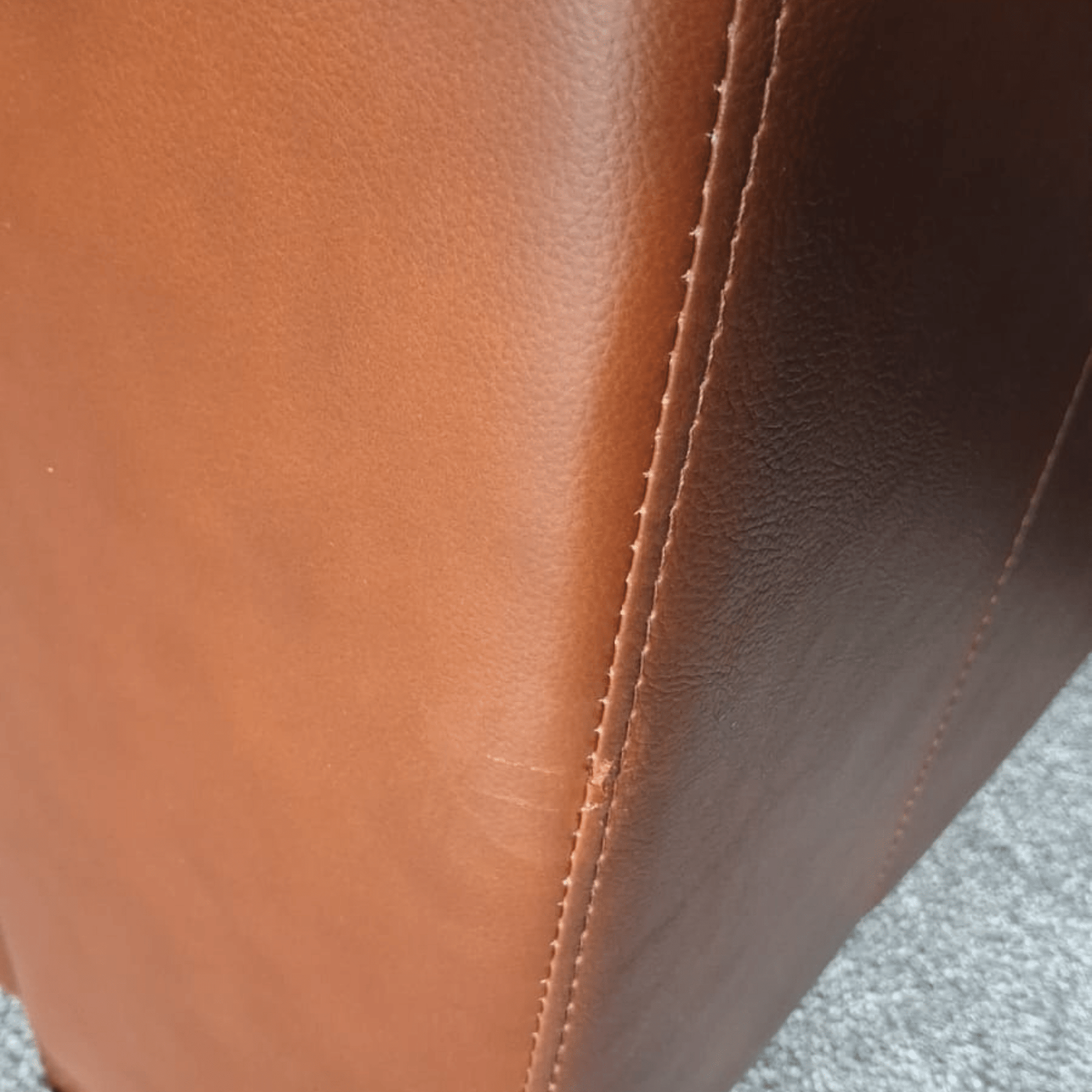Close-up of brown leather surface with visible stitching