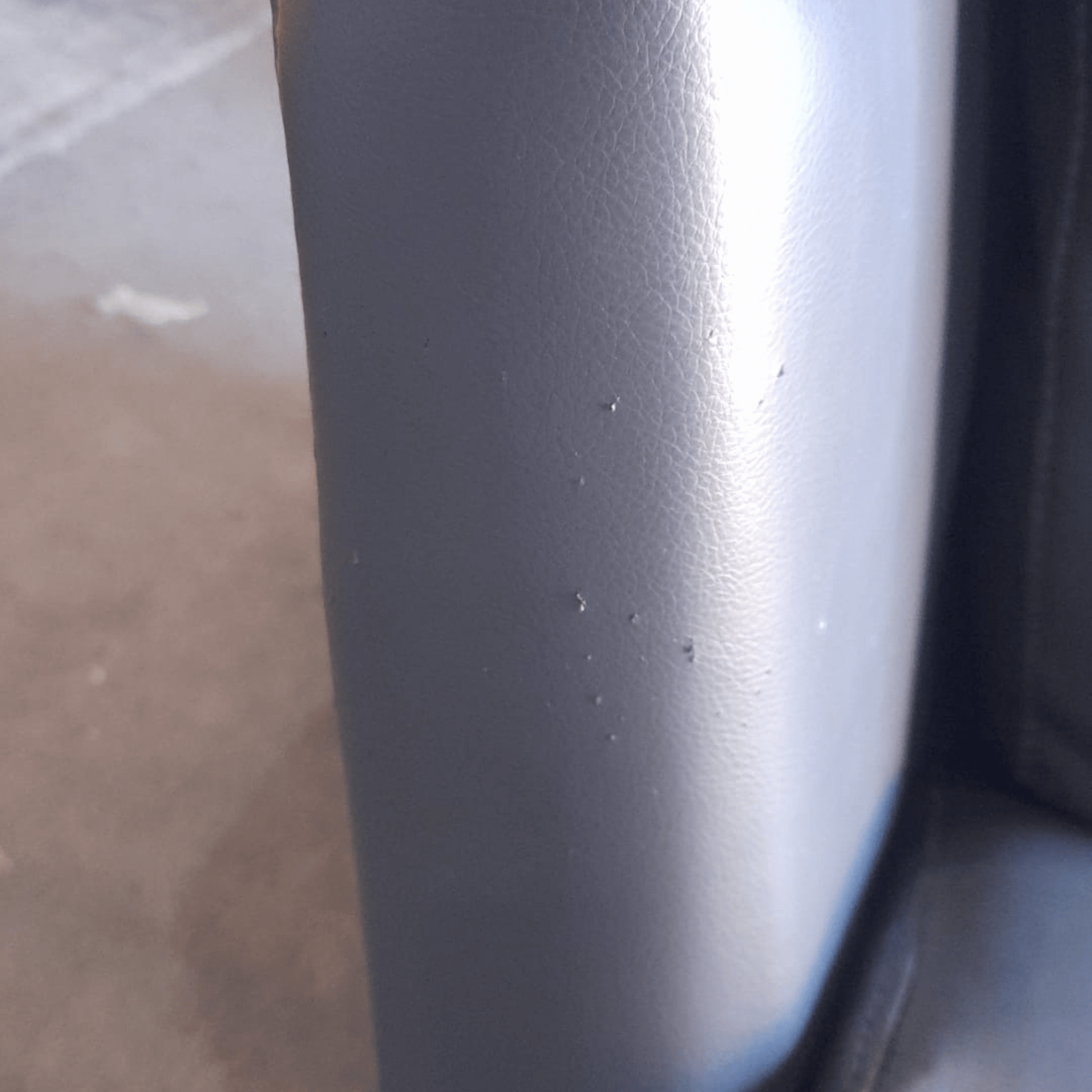 Close-up of a dark gray or black object with a blurred background