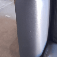 Close-up of a dark gray or black object with a blurred background