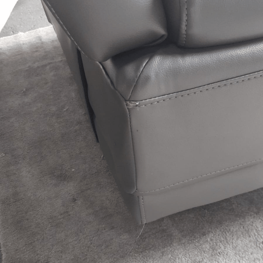 Gray leather armchair corner on a gray carpet