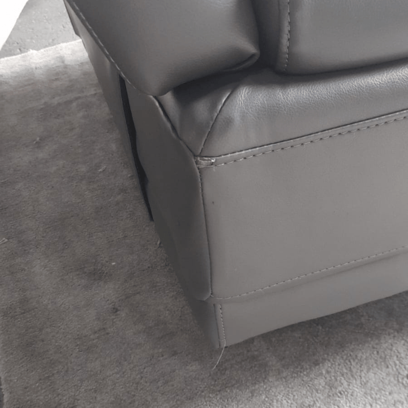 Gray leather armchair corner on a gray carpet
