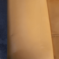 Close-up of a brown leather surface with a textured pattern.