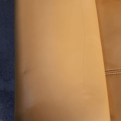 Close-up of a brown leather surface with a textured pattern.