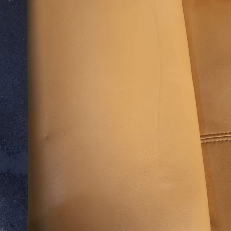 Close-up of a brown leather surface with a textured pattern.