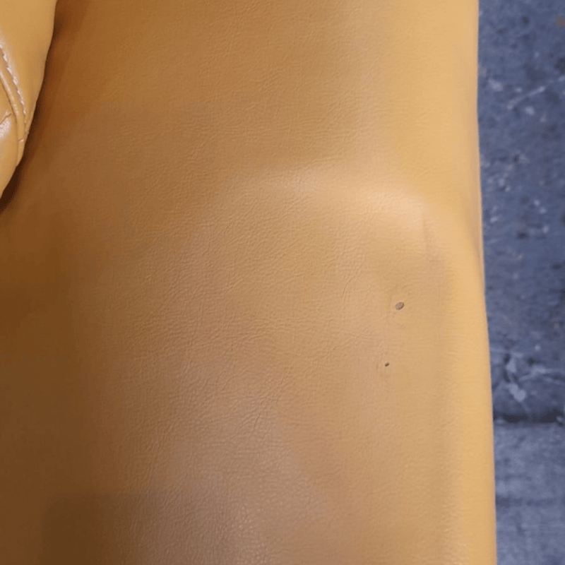 Close-up of a brown leather surface with a visible scratch.