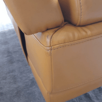 Close-up of a yellow leather chair with visible wear on a gray carpet.