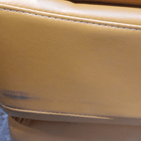 Close-up of a yellow leather surface with visible stitching