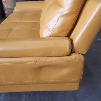 Close-up of a brown leather sofa corner on a blue carpet