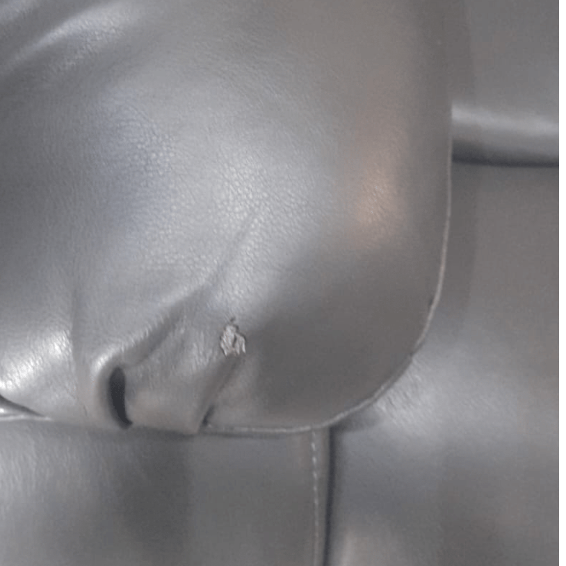 Close up of the armrest on the Valerie grey leather 3-seater sofa, highlighting the smooth texture and stitching detail    