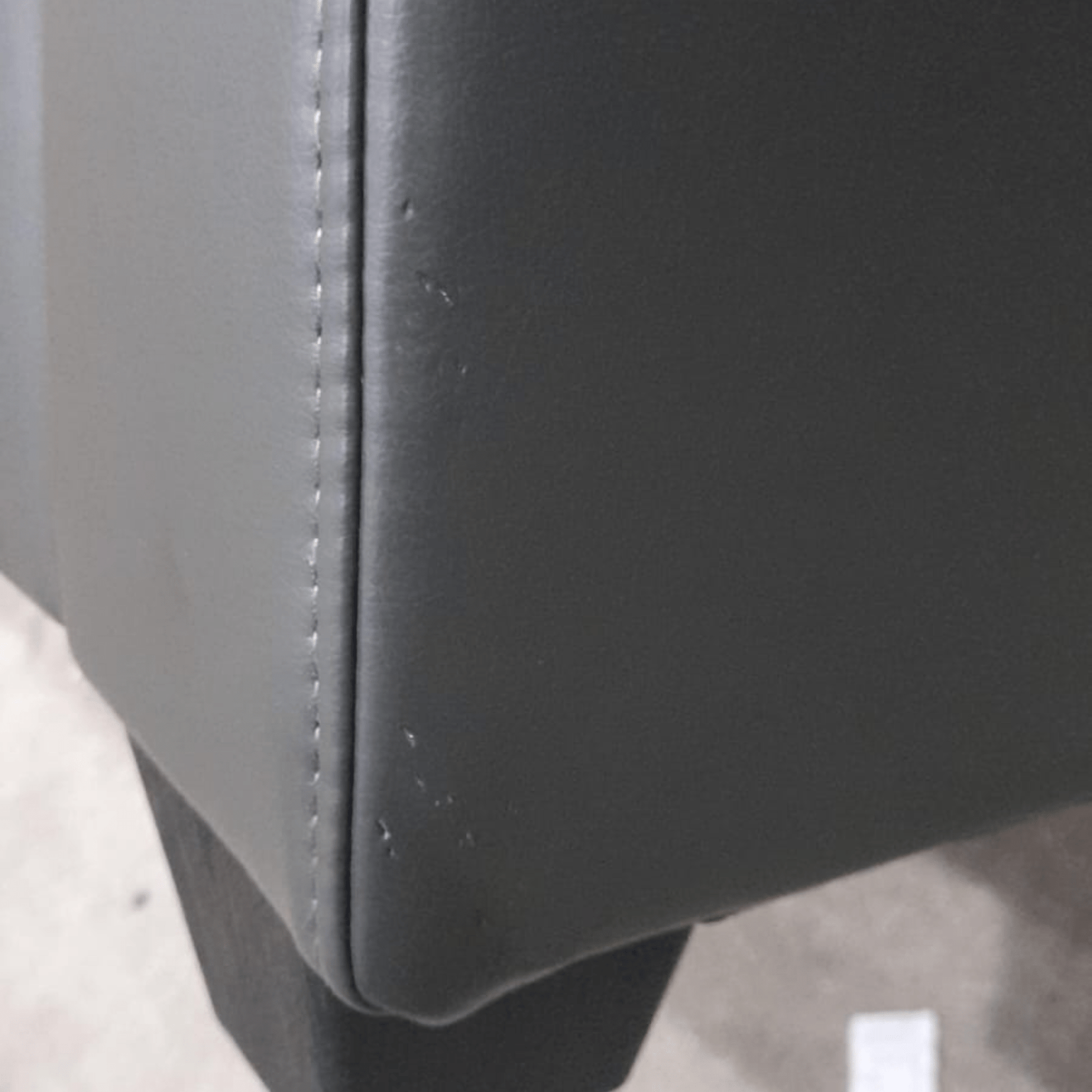 close up of grey leather sofa of marks on corner.
