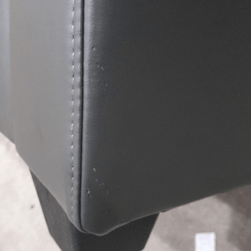 close up of grey leather sofa of marks on corner.