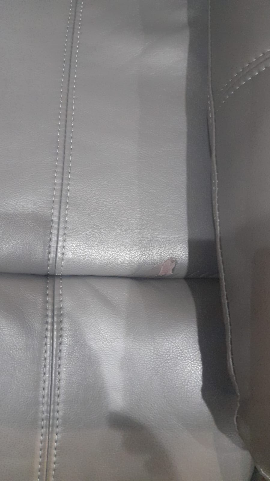 Close-up detail of the Valerie grey leather armchair showcasing texture and stitching