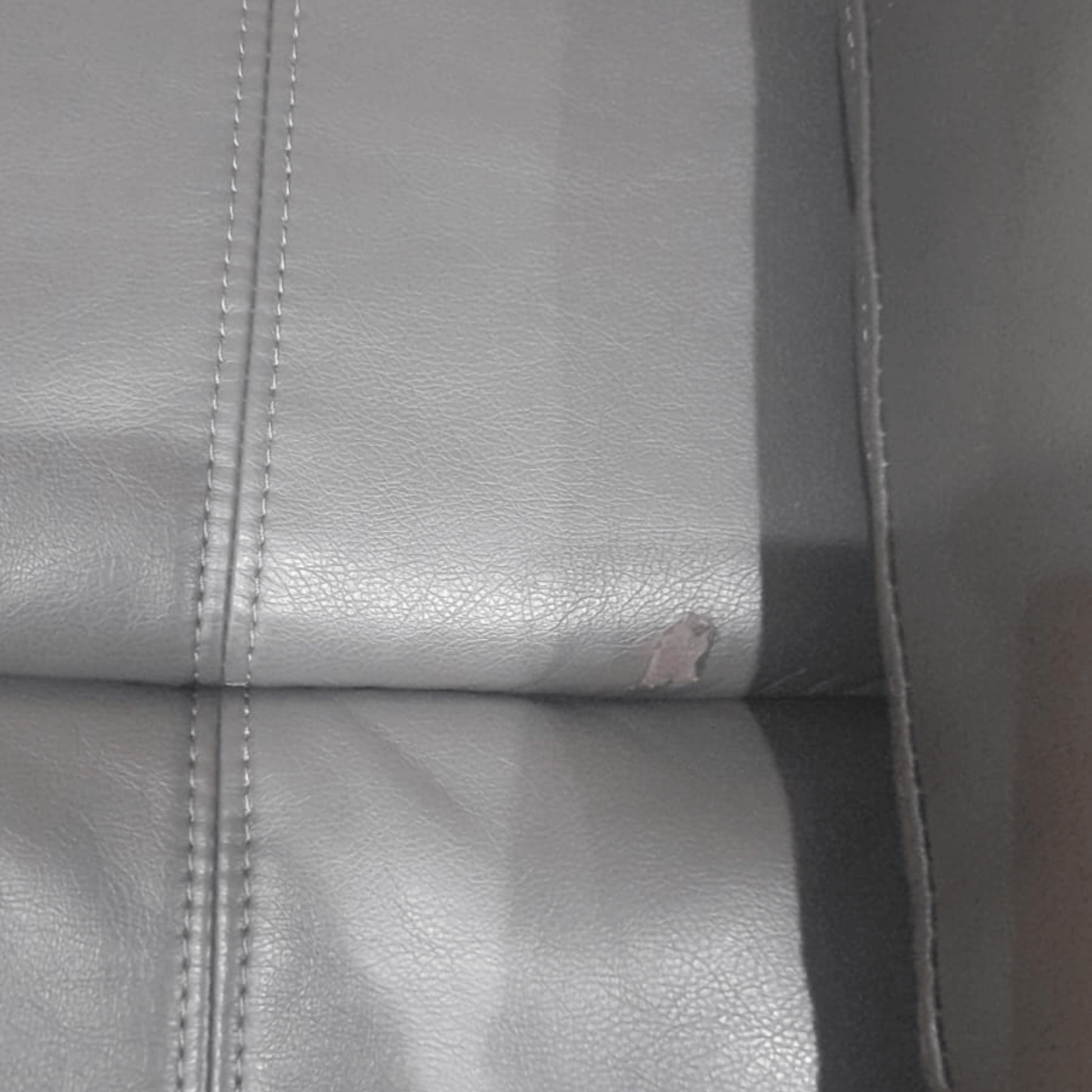  Close-up detail of the Valerie grey leather armchair showcasing texture