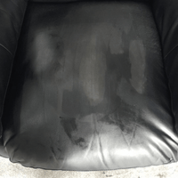 Black leather chair with visible wear and stains