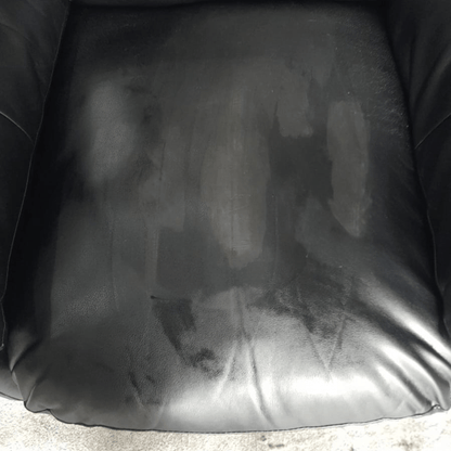 Black leather chair with visible wear and stains
