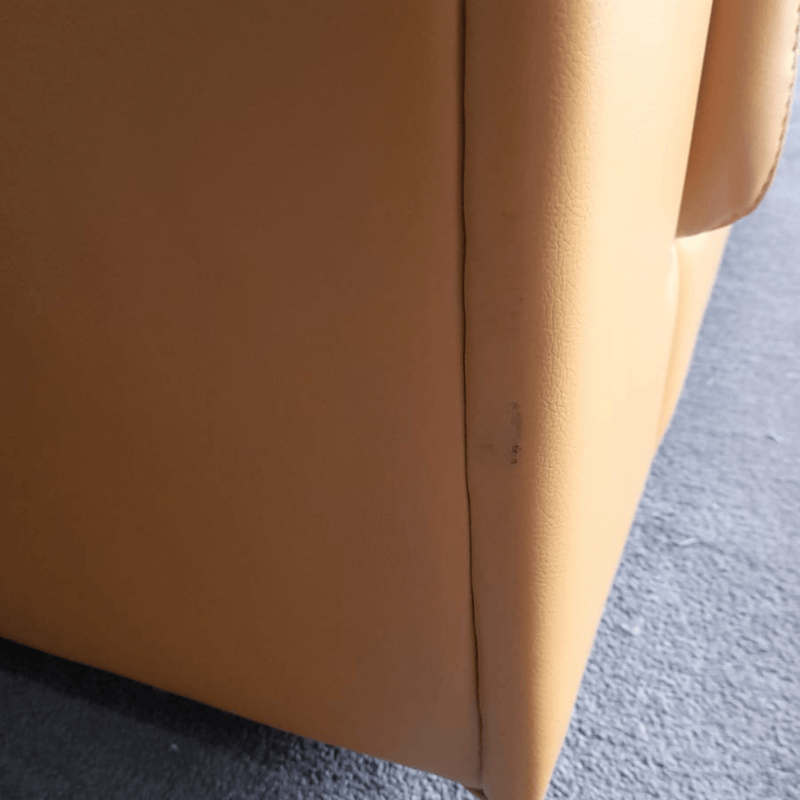 Close-up of a yellow sofa corner on a blue carpet