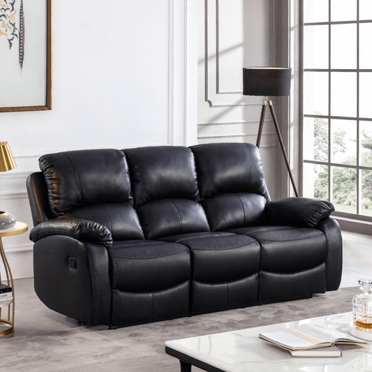 Black leather sofa in a living room setting with a lamp and table.