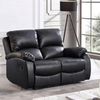 Black leather recliner sofa in a living room setting with a lamp and window in the background.