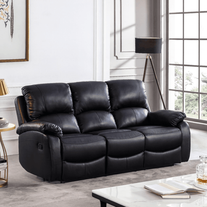 Black leather sofa in a living room setting with a lamp and table.