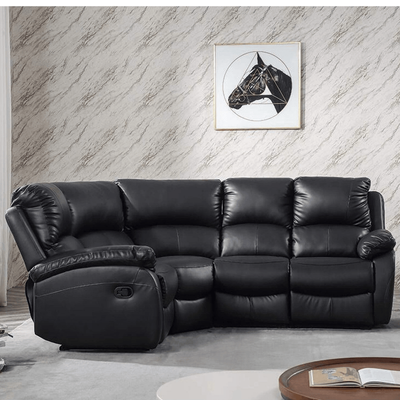 Black leather sectional sofa in a living room with a marble wall and framed picture.