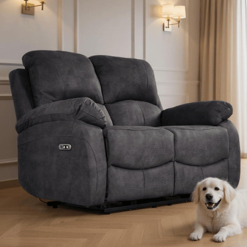 Gray recliner sofa in a living room with a white dog sitting next to it.