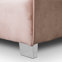 Close-up of a pink sofa corner with chrome legs on a light gray background