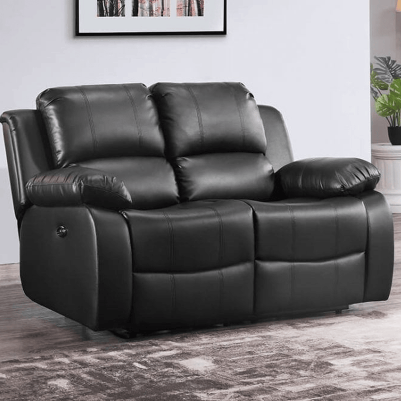 Black leather reclining sofa in a room with a plant and framed picture on the wall.