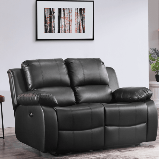 Black leather recliner sofa in a living room setting with a framed picture on the wall.