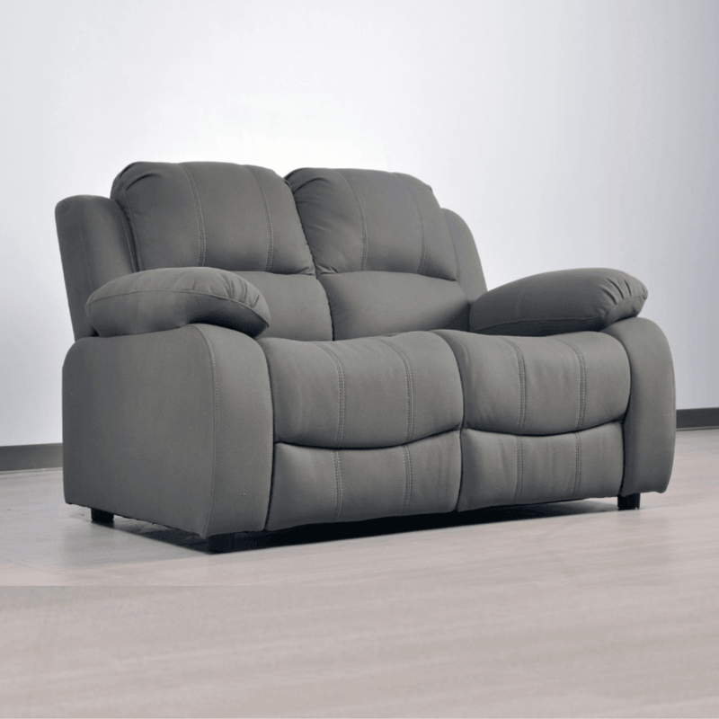 Gray recliner sofa on a light gray floor with a white wall background