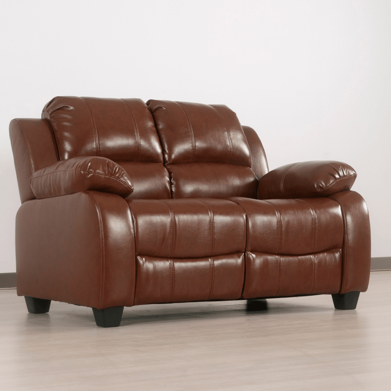 Brown leather sofa on a light wooden floor with a white wall background