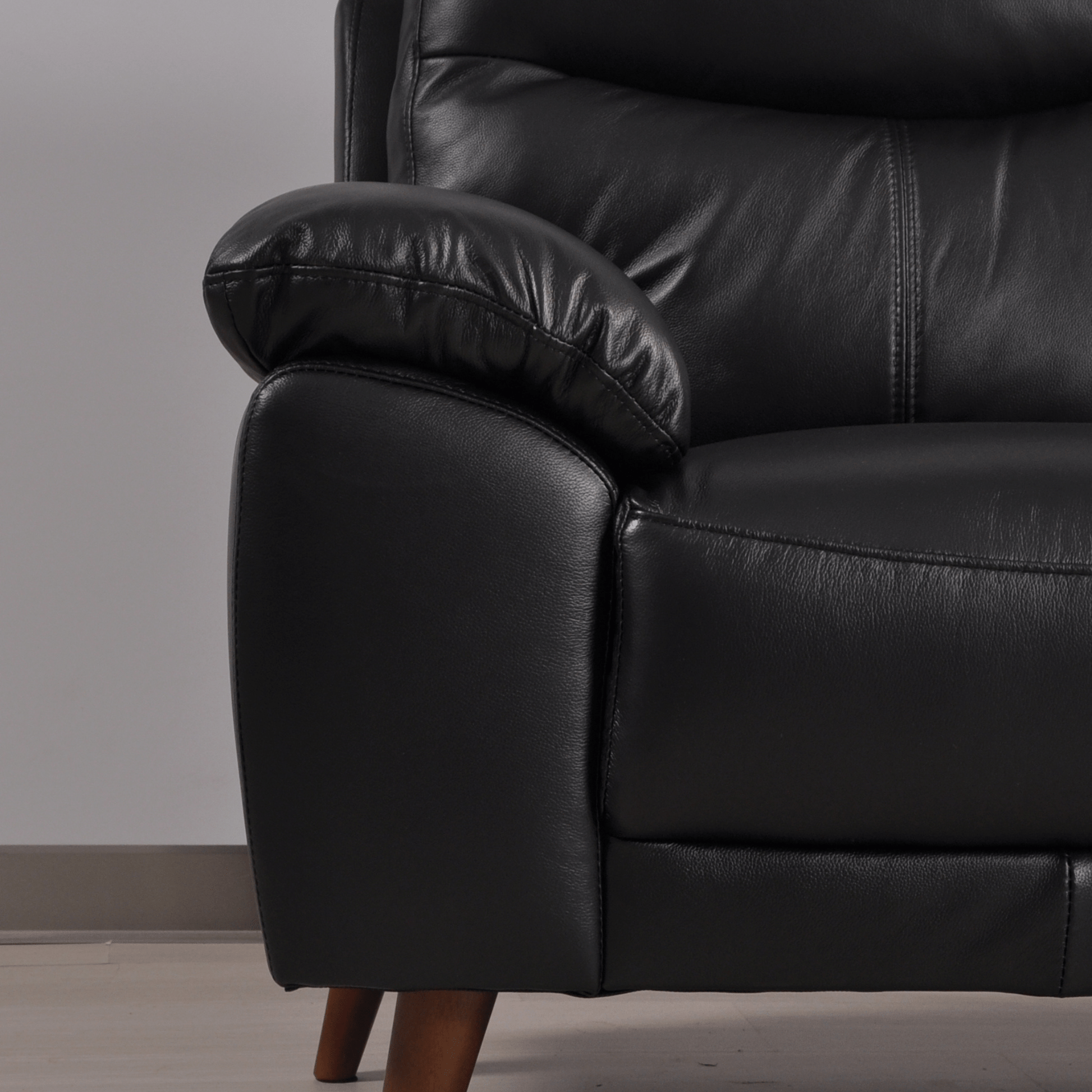 Close-up of Vantage black 2-seater sofa with soft upholstery and detailed stitching