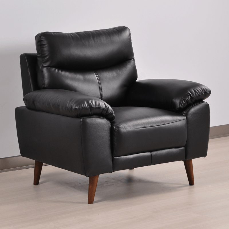 Vantage black armchair at an angle in a contemporary living room with neutral decor and soft lighting