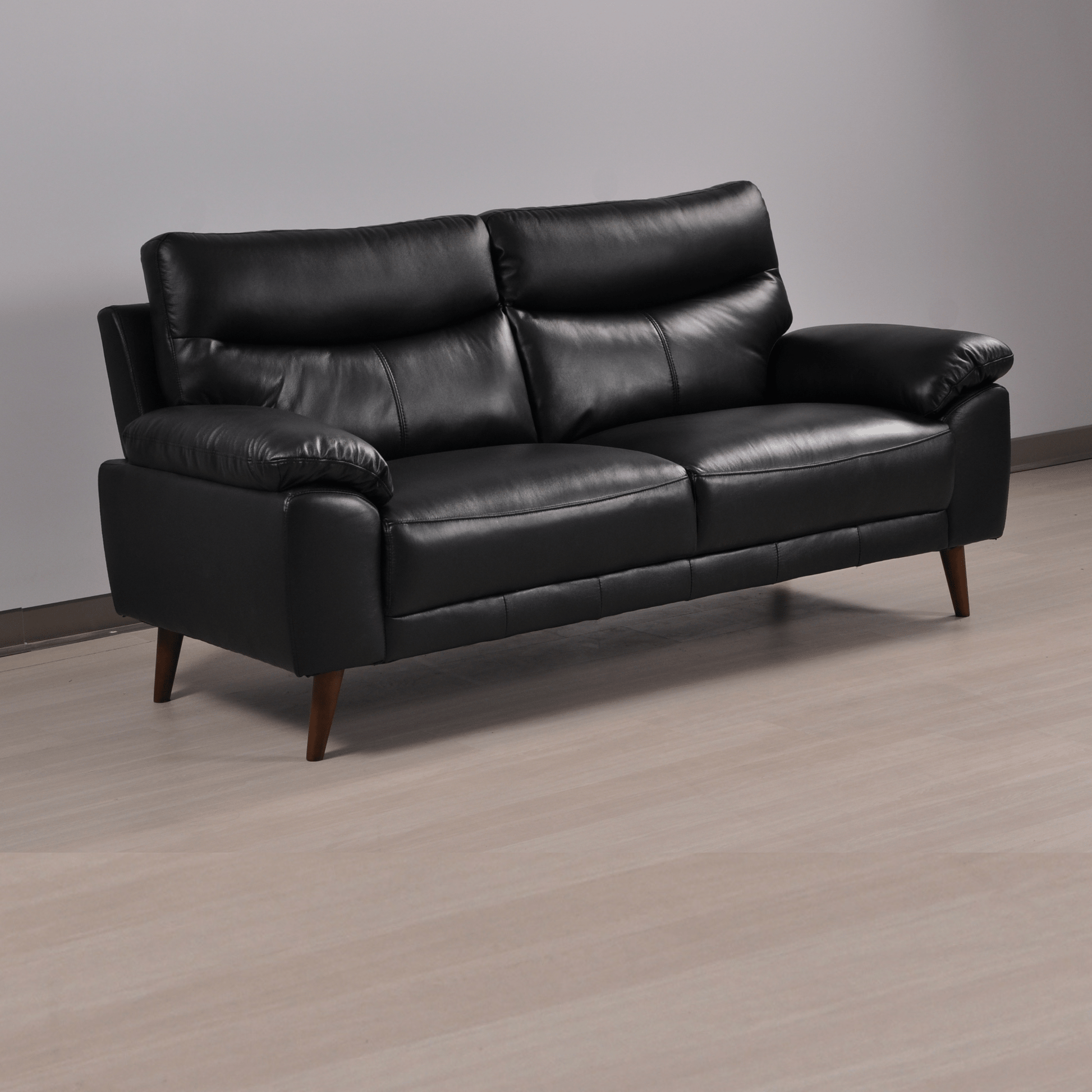 Vantage black 3-seater sofa at an angle in a contemporary living room with neutral tones and warm lighting